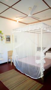 1 cama con dosel blanco en una habitación en Salty Garden, en Matara