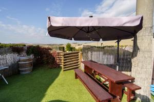 - un banc en bois avec un parasol dans le jardin dans l'établissement La casina dei Praticelli, à Castelfiorentino