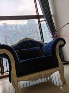 ein blaues Sofa in einem Zimmer mit Fenster in der Unterkunft Meiju Apartment in Guangzhou