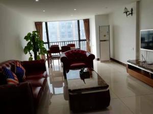 a living room with a couch and chairs and a table at Meiju Apartment in Guangzhou