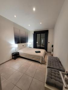 um quarto grande com uma cama e um sofá em APPARTEMENT standing 2 pieces avec jardin entre Paris & Dysney em Bry-sur-Marne