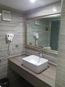 a bathroom with a white sink and a mirror at Meiju Apartment in Guangzhou