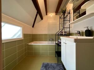 uma casa de banho com um lavatório e uma banheira em Petite Etoile Cozy House em Marlenheim