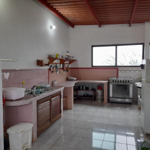 uma grande cozinha com um lavatório e um fogão em Los Tucanes em Los Altos de Cerro Azul