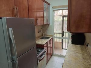 a kitchen with a stainless steel refrigerator and a window at Luxury King Bed with garden-Zayed Families only in Sheikh Zayed