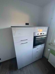een witte keuken met een fornuis en een oven bij Zechenbude - Erlebe das Ruhrgebiet in Gladbeck