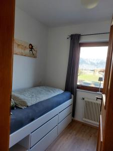 a small bedroom with a bed and a window at Haus Muigg in Innsbruck