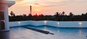 a swimming pool with a sunset in the background at Ivory Laze Hotel in Negombo
