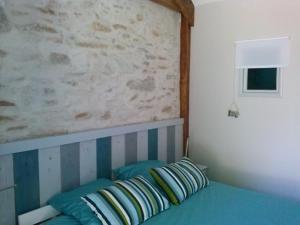 1 dormitorio con 1 cama con 2 almohadas en Chambre d'Hôtes le massanous, en Laure-Minervois