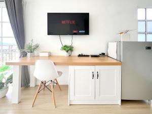 a desk in a kitchen with a tv on the wall at Cozy Suite - Near UTAR - Champs Elysees Kampar in Kampar