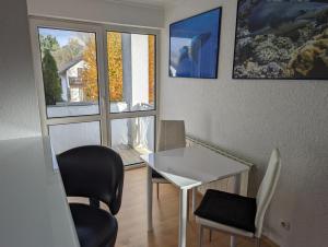 Zimmer mit einem Tisch, Stühlen und einem Fenster in der Unterkunft Ruhige, moderne Wohnung bei Darmstadt in Roßdorf in Roßdorf