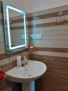 een badkamer met een witte wastafel en een spiegel bij Abhishek Villa in Kekanadura