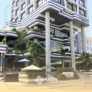 un gran edificio con sombrillas delante en Odin Hotel Quy Nhon, en Quy Nhon