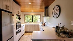 cocina grande con reloj grande en la pared en Glenorchy Lake House, en Glenorchy