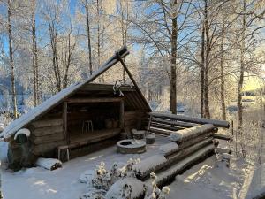Cabaña de madera con techo cubierto de nieve en Row house in Meltosjärvi, en Meltosjärvi