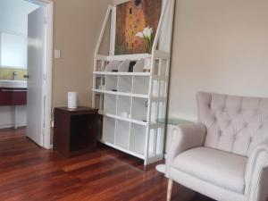 a living room with a chair and a book shelf at Mt Eden Master Suite RM1 in Auckland