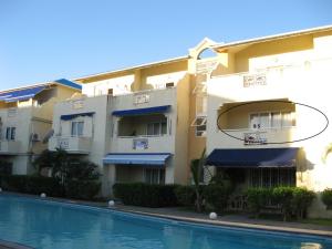 a building with a swimming pool in front of it at Grenadier A in Flic-en-Flac