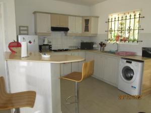 a kitchen with a counter and a washing machine at Grenadier A in Flic-en-Flac