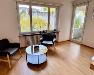 uma sala de estar com duas cadeiras e uma mesa em Gemütliche Wohnung Nähe Uni em Basileia