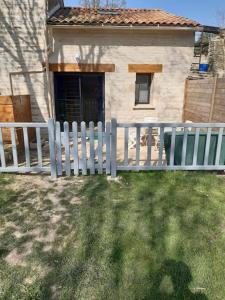 a white fence in front of a house at Agréable gite au calme in Marigny