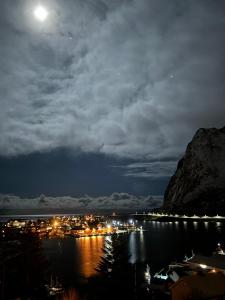 a view of a harbor at night with the moon at Lofoten Bed & Breakfast Reine - Rooms & Apartments in Reine