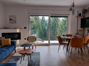 a living room with a blue couch and a table and chairs at GO Jahorina by Olympic Gardens in Jahorina