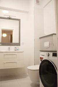a bathroom with a toilet and a sink and a mirror at Scandinavian for you in Bacău