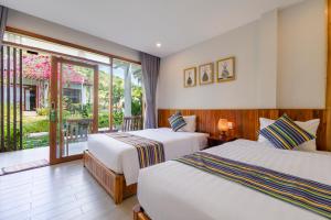 a hotel room with two beds and a balcony at Suối Mây Phú Quốc Garden Resort in Phu Quoc +81 photos