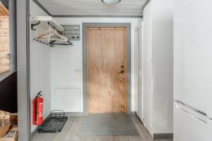 einen Flur mit einer Holztür und einem Feuerlöscher in der Unterkunft Björnbyn in Sälen