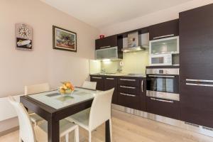 a kitchen with a black table and white chairs at Apartment Miaa in Split