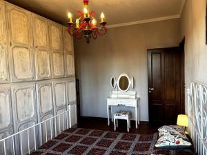 Cette chambre comprend un lustre et une table avec un miroir. dans l'établissement Intero alloggio: appartamento, à Turin