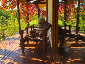 a porch with two rocking chairs on a deck at Valley Farm Vineyard Villas in Healesville