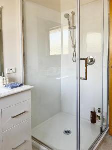 a shower with a glass door in a bathroom at Convenient Westfield House 3bed 2bath in Christchurch