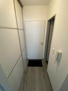un pasillo de una oficina con una puerta y una puerta Sidx sidx en Apartment Kompakt 24/7, en Kassel