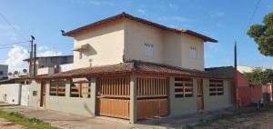 a large house with a garage in front of it at Apartamento Guriri Verão in São Mateus