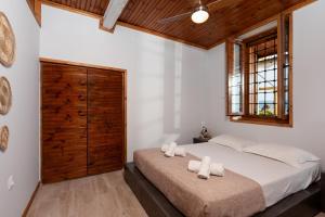 1 dormitorio con 1 cama grande y 2 toallas blancas en The Sea Front Fisherman’s house, en Kato Gatzea