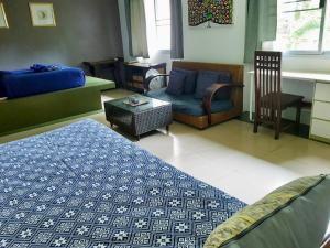 a bedroom with a bed and a chair and a table at Good Time Sports Village Koh Mak in Ko Mak