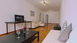 - un salon avec un canapé et une table avec des verres à vin dans l'établissement STAY Virtuoso Apartment Nicosia, à Nicosie