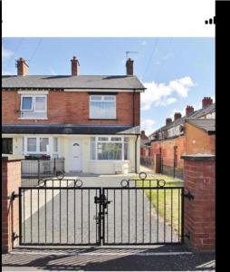 uma casa com um portão em frente em Stylish & Convenient em Belfast
