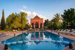 uma piscina em frente a um gazebo em Nomadz Palace em Marrakech