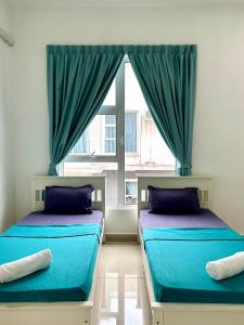 two beds sitting in a room with a window at Hom Villa 5rm 12-22 pax Wifi Netflix BBQ SteamBoat Games Beach Water Park in Kota Tinggi