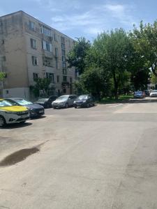 a parking lot with cars parked in front of a building at Apartament in complex rezidențial in Râmnicu Vâlcea +3 photos