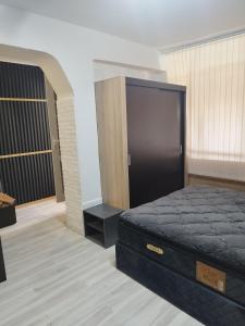 ein Schlafzimmer mit einem Bett und einem großen Schrank in der Unterkunft Апартамент за гости Централ in Malko Tŭrnovo