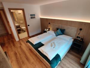 a bedroom with a large bed with two towels at Apartment Villa Stefania in Selva di Val Gardena