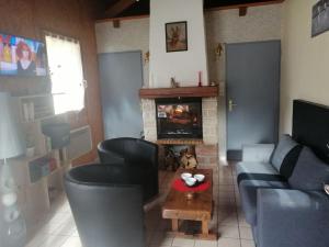 ein Wohnzimmer mit einem Sofa und einem Kamin in der Unterkunft Chaleureux gîte des brocards aux pieds des sapins 3 étoiles in Allarmont