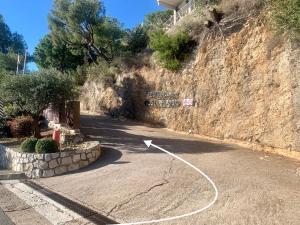 a road with a sign on the side of a hill at SARA RIVIERA Costa Plana in Cap d'Ail