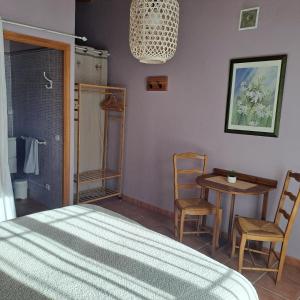 um quarto com uma cama, uma mesa e cadeiras em la chambre de l'auxineill em Castelnou