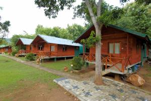 a row of cottages in a forest with a tree at The Mastodon Valley Safari Resort in Udawalawe