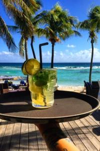 a drink sitting on a table on the beach at Studio Kaz Ananas au Manganao in Saint-François