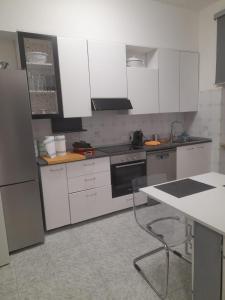 une cuisine avec des placards blancs et une table. dans l'établissement VinicioRossiApartment, à Ancône